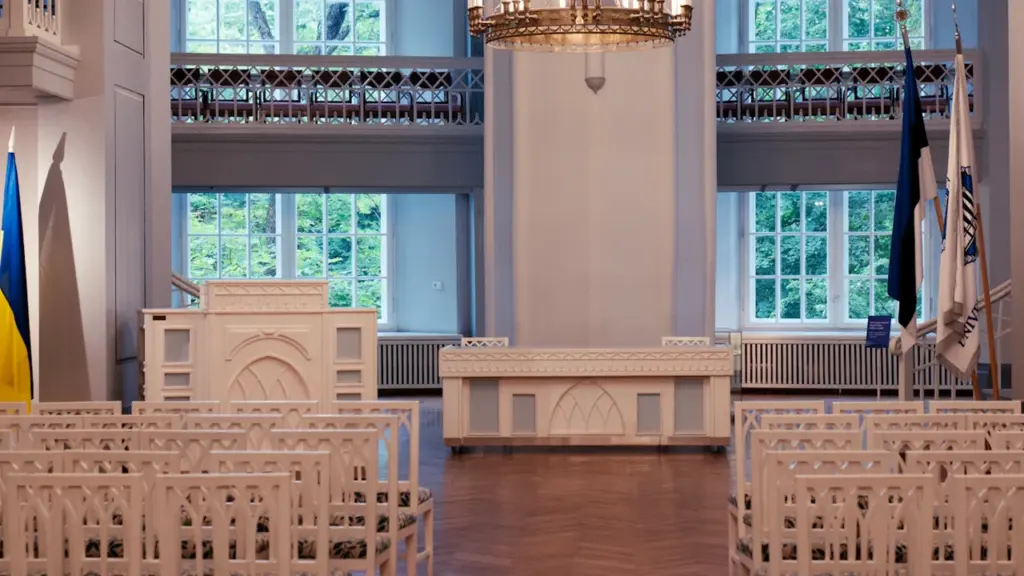 Tartu ülikooli aulas toimuv mälestustseremoonia ettevalmistus koos Eesti lipuga ja pidulike toolidega.