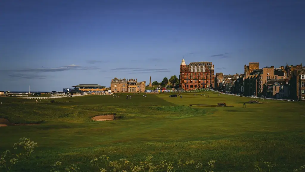 Panoraamvaade golfiväljakule, mille taustal paistavad eluhooned ja roheline maastik.